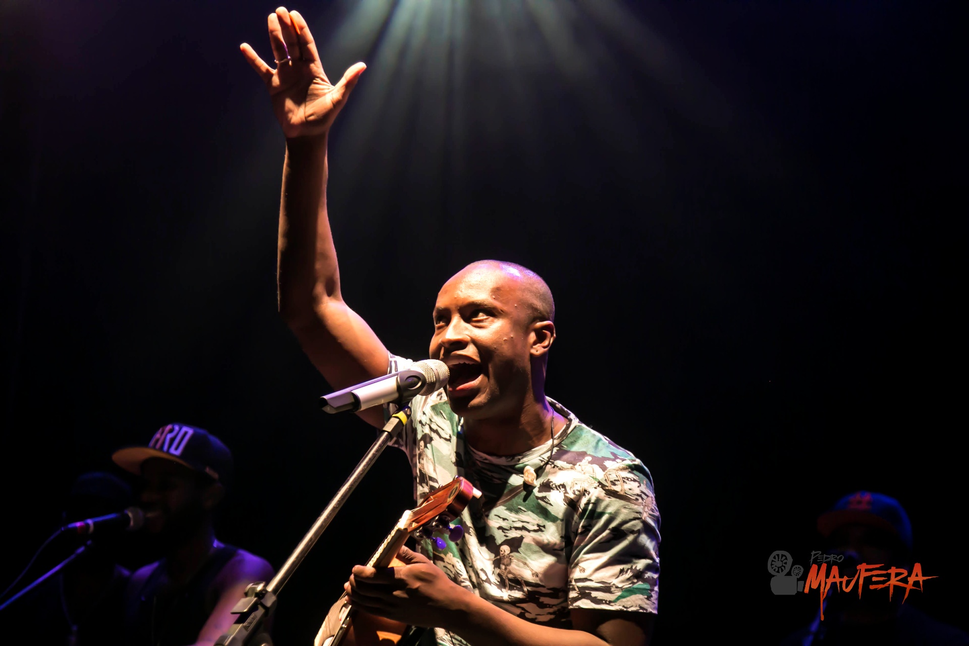 Thiaguinho com mão erguida no palco