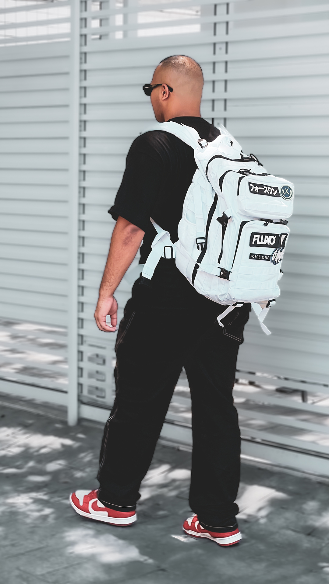 Rogerinho caminhando com mochila e tênis vermelho