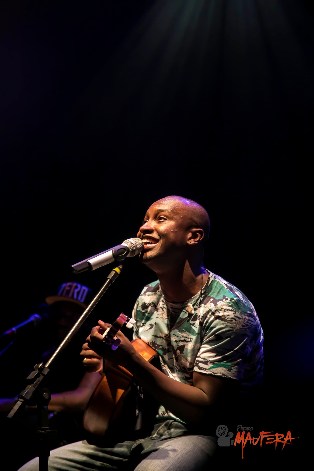 Thiaguinho sorrindo sob feixe de luz
