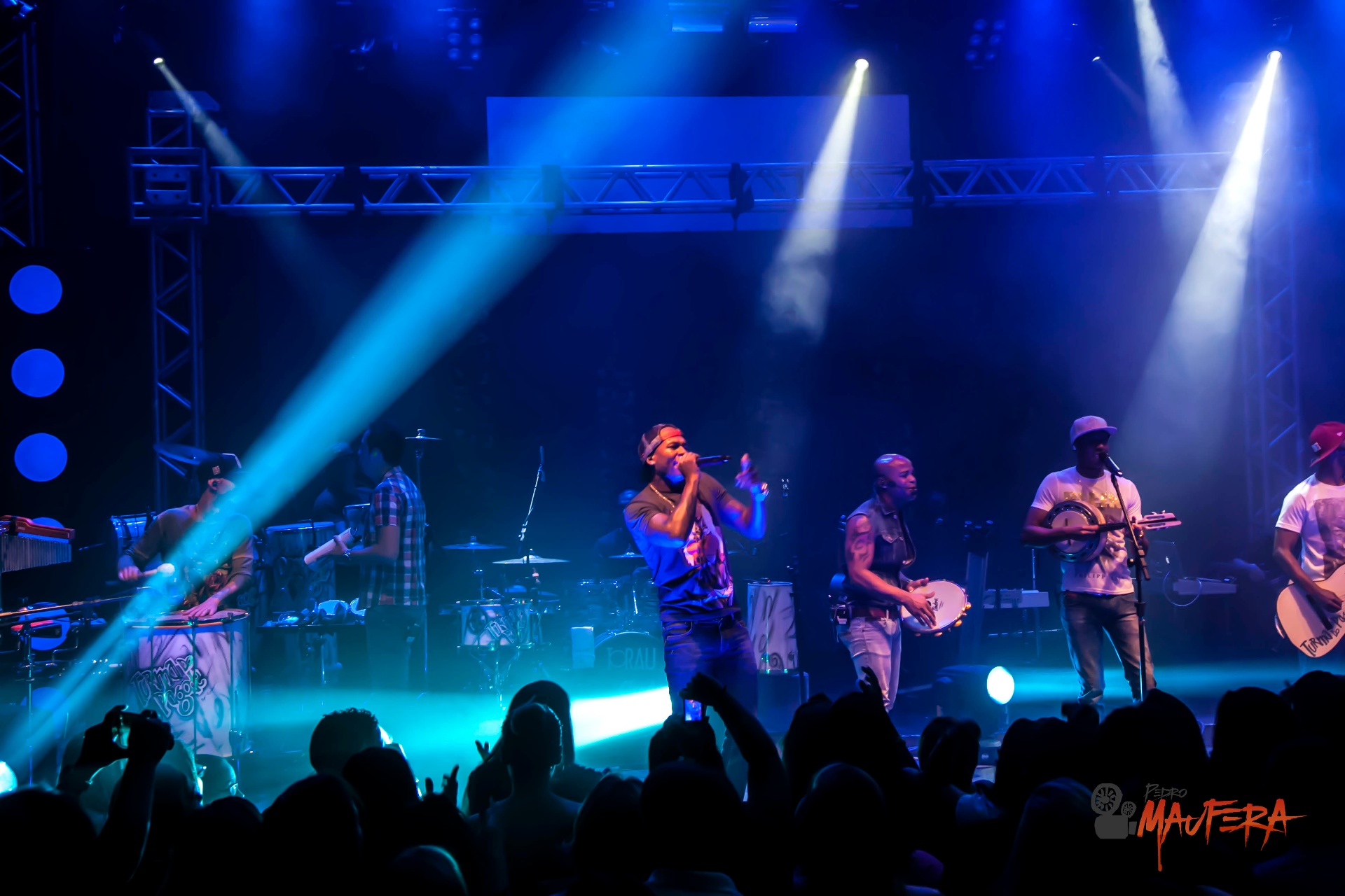 Turma do Pagode com feixes de luz azul no palco