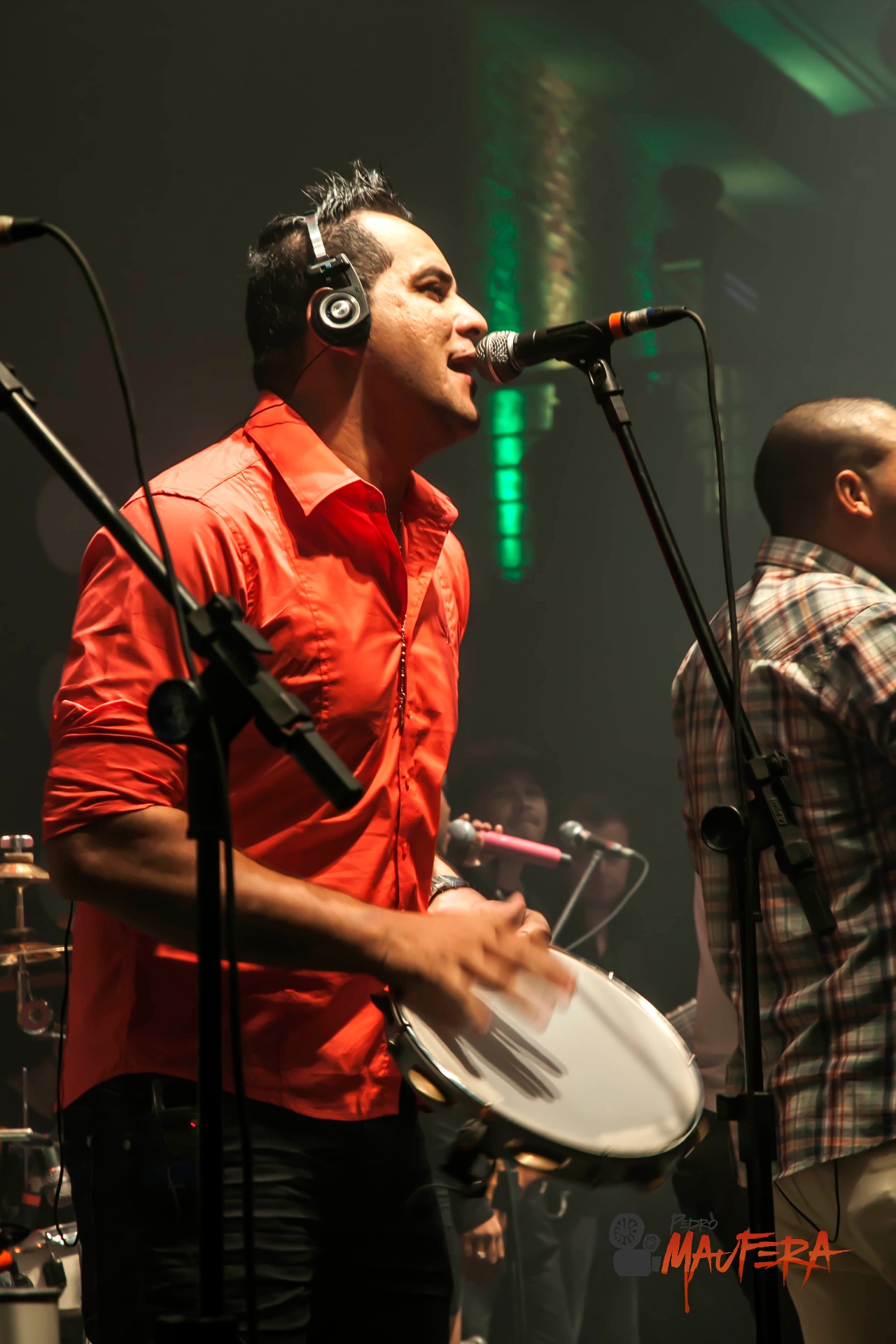 Vocalista de camisa vermelha com pandeiro