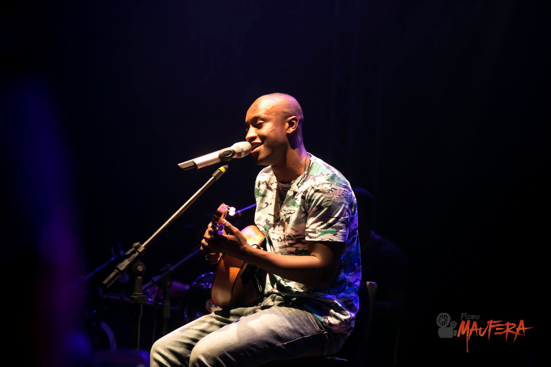Thiaguinho tocando cavaco sob luz azul