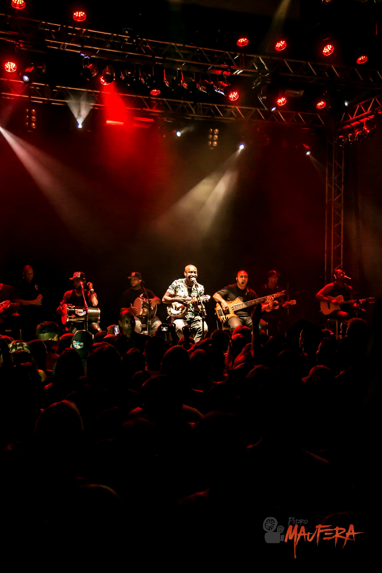 Palco vertical com Thiaguinho e banda sob luz vermelha