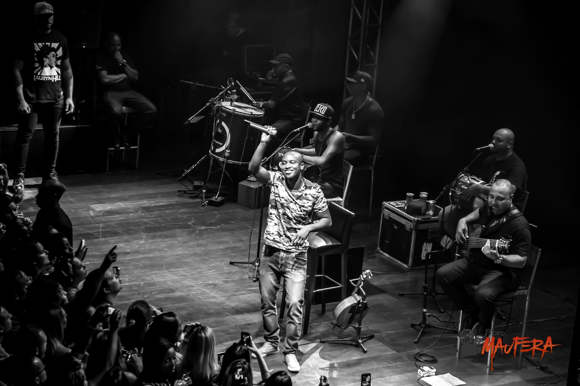 Thiaguinho com microfone erguido em show acústico